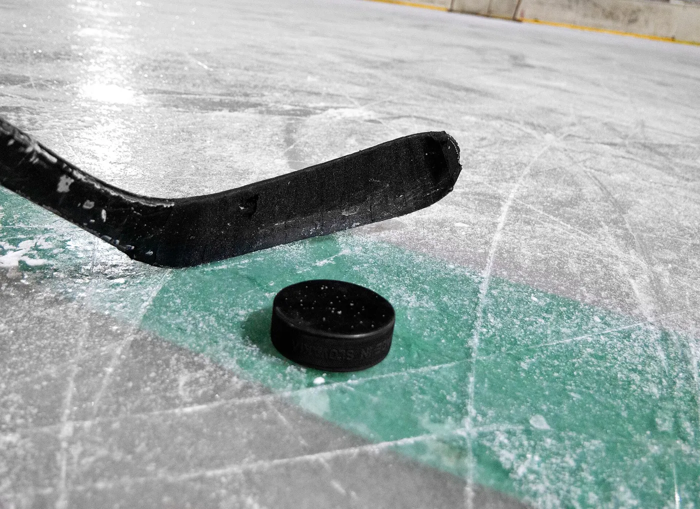 hockey stick and puck on a rink